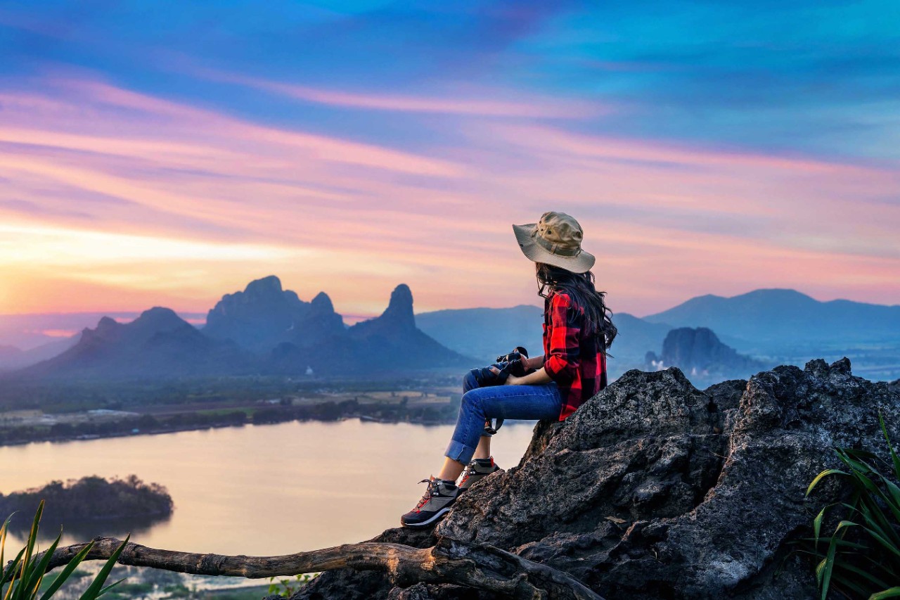 Tourist sitting on Phu sub lek viewpoint at sunset, Lopburi, Thailand.